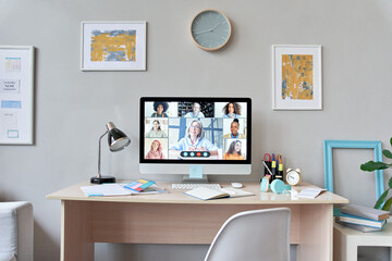 Home room interior with computer monitor group online lesson on student table. Distance learning virtual remote class, homeschool concept, video conference call with teacher and children on pc screen.