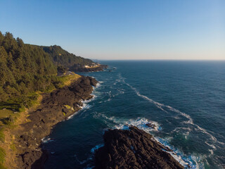 Fototapeta na wymiar Aerial drone panoramic view of rocky cost in the ocean waves. Beautiful sunny weather. Amazing natural landscape. View from above.