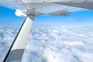 Aeroplane wing. Fluffy clouds under the wing of the plane.