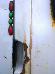 Metal corrosion of an old truck. Rusty messy surface. Damaged grunge dirty texture from road salt. Rust background. Protection and paint car. Professional repair. Messy. Coat. Red and green lamp.