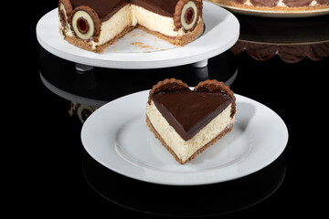 a slice of Dutch pie covered with chocolate ganache on a reflective dark background