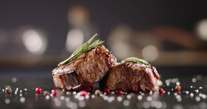 Beautiful peaces of grilled meat decorated on plate with rosemary and various spices. Art cookery being prepared before serving 4k footage