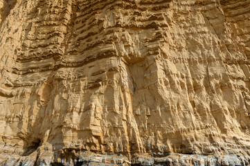 The imposing and eroded sandstone cliffs exposing millions of years of sedimentary geological layers. West Bay in Dorset on the Jurassic coast.