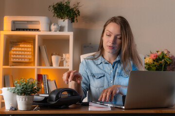 Young female manager takes phone at her workplace in office, for important call. Concept of working moments and office lifestyle.