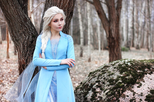 Young attractive girl with long blond hair in blue dress