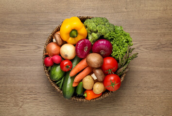 Different fresh vegetables on wooden table, top view