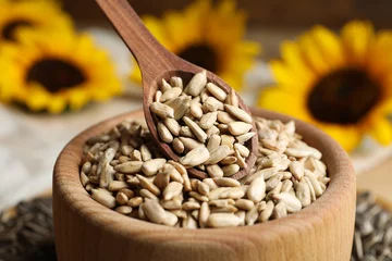 Rolgordijnen Raw peeled sunflower seeds in wooden bowl, closeup © New Africa
