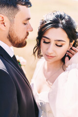 Wedding couple close-up portrait on the background of a field of natural landscape