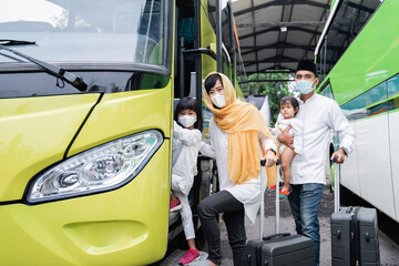 happy asian muslim holiday trip riding a bus together with family wearing mask preventing virus spread
