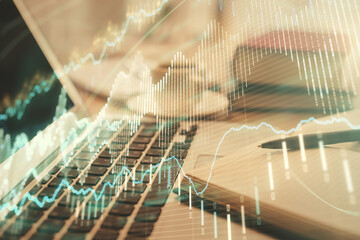 Double exposure of financial chart drawing and desktop with coffee and items on table background. Concept of forex market trading