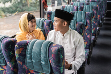 Fototapeta na wymiar muslim couple travel by bus during eid mubarak holiday to meet family at home