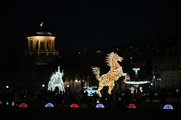public Christmas decoration, light on statues of horse, elephant and sport car on the public palace...