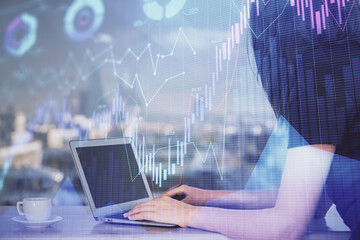 Double exposure of businesswoman hands typing on computer and forex chart hologram drawing. Financial analysis concept.