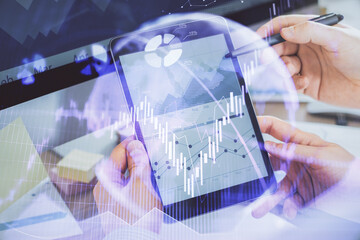 Double exposure of man's hands holding and using a phone and financial chart drawing. Market analysis concept.