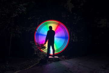 One person standing alone against creative color circle light painting as the backdrop	