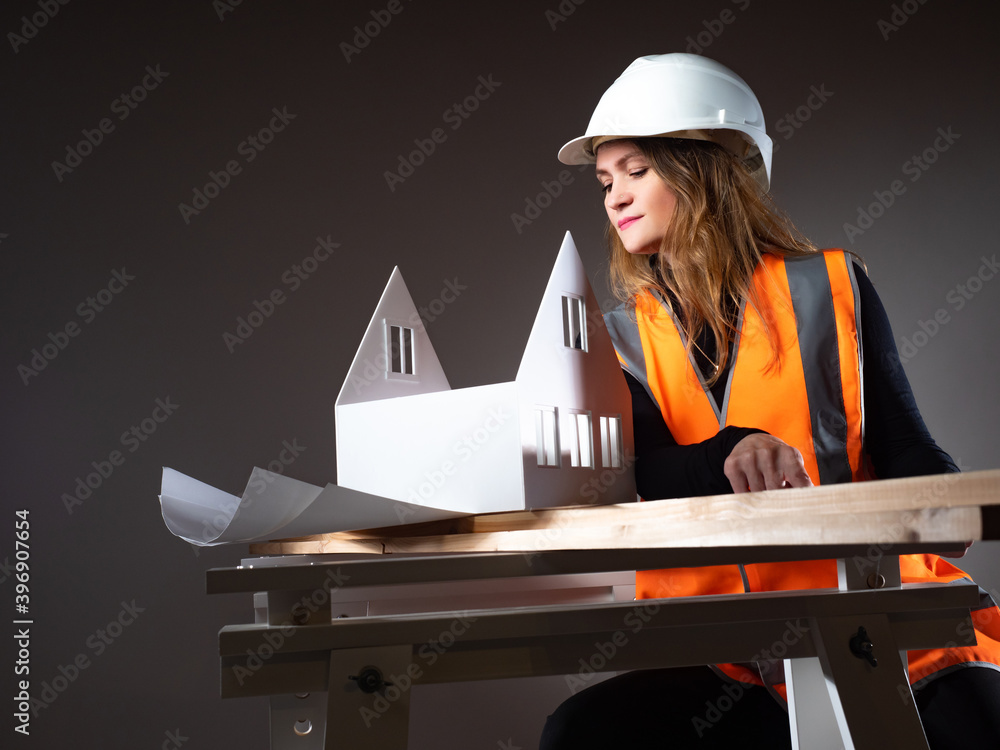 Poster a female architect is preparing the layout of a new house. design in construction. close-up of a you
