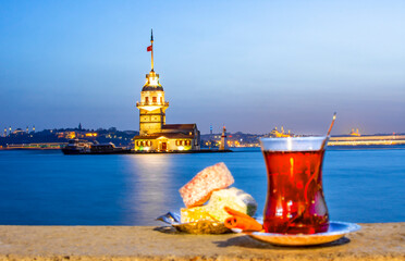 Magnific view of Maiden's Tower (aka Kiz kulesi) at night time on the background and traditional...