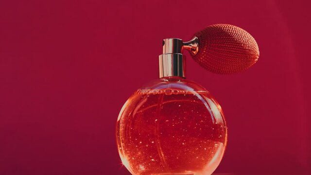 Vintage perfume bottle and shining light flares on red background, glamorous fragrance scent as luxury perfumery product for cosmetic and beauty brand, stock footage
