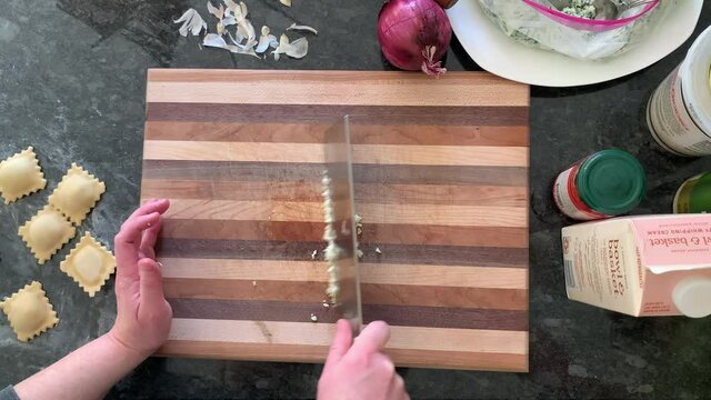 Woman chopping garlic with a big knife
