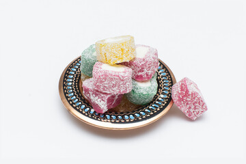 Obraz na płótnie Canvas Colorful Turkish delight (aka lokum) in traditional bowl isolated on white background. Middle Eastern dessert popular in the month of Ramadan. 
