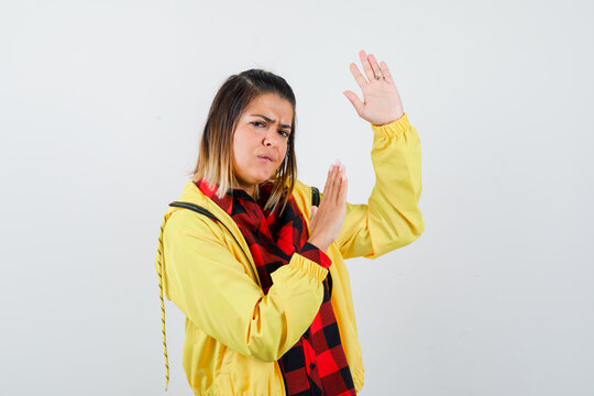  Cute Woman In Shirt, Jacket Showing Karate Chop Gesture And Looking Serious , Front View.