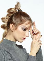 Portrait of blonde female with creative braid hairdo.