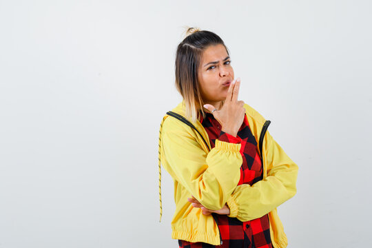 Portrait Of Cute Woman Blowing Into The Barrel Of Finger Gun In Shirt, Jacket And Looking Confident Front View