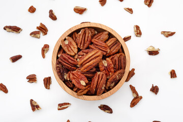 Pecans in wood bowl on white background