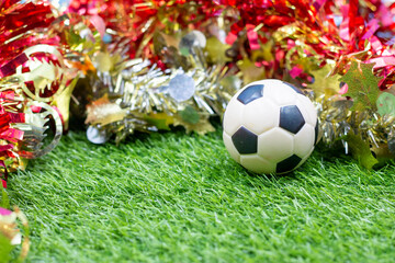 Soccer Christmas ball with Christmas decoration on green grass