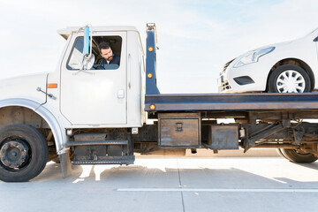 Operator towing a dead car on a tow truck