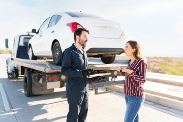 Mechanic and young woman in a discussion about the cost of his services
