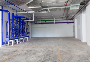 Parking garage interior, industrial building, hydrant with water hoses and fire extinguisher equipment , water pipe valve,pipe for water piping system control in industrial building