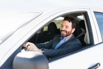Fototapeta na wymiar Profile of a happy male driver behind the wheel