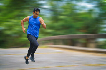 Fototapeta na wymiar sportman runner practicing sprinting run on road in park in morning