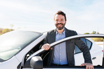 Latin man making eye contact while smiling and getting off a vehicle