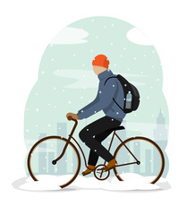A young man on a bicycle, rides through the park when it snows.