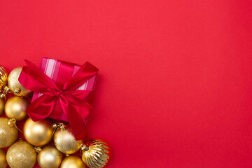 christmas red background with golden christmas balls and gift box with bow