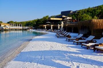 View of nice empty sandy beach with some tropical bungalow. Banner, lots of copy space.