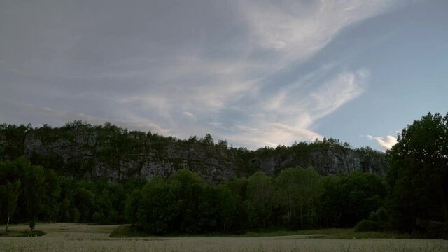Calm time lapse of cornfield, trees and mountains at sunset time. Southern Norway