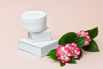 Fototapeta na wymiar Beauty industry concept. White cosmetic cream jar top with flowers. Side view. Feminine hygienic skincare product on light pink background.