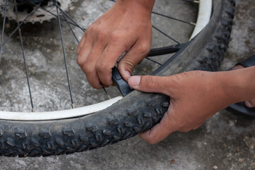 The hand of a mechanic is changing the tires of the bicycle.