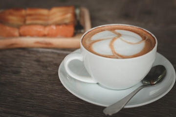 Close-up of a coffee latte on an old wooden floor
