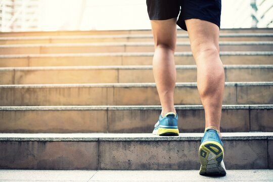Close up portrait of  an athletic running on staircase steps jogging to build muscle endurance.fitness and healthy lifestyle concept
