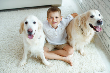 Little boy with a dog at home on the carpet. Friendship, care, happiness, new concept of the year. High quality photo.