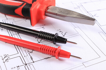 Cables of multimeter and pliers on construction drawings of house. Building home concept