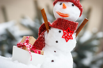 Decorated snowman with gifts for Christmas or Valentine on background of coniferous tree covered...