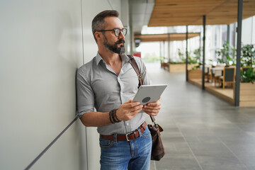 Lifestyle of man hipster freelancer standing and holding laptop at office terminal corporate,...