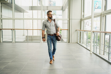 Lifestyle of man hipster freelancer standing and holding laptop at office terminal corporate, professional freelance man concept