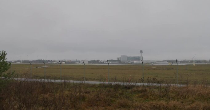 Slow wide pan of the Arlanda airport on a cloudy and rainy day in Stockholm