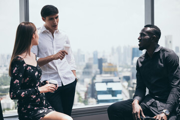 Multiracial friends sitting in cafe enjoying coffee during work break, listening to Caucasian male talking and sharing thoughts, diverse colleagues meeting in coffeeshop discussing business project